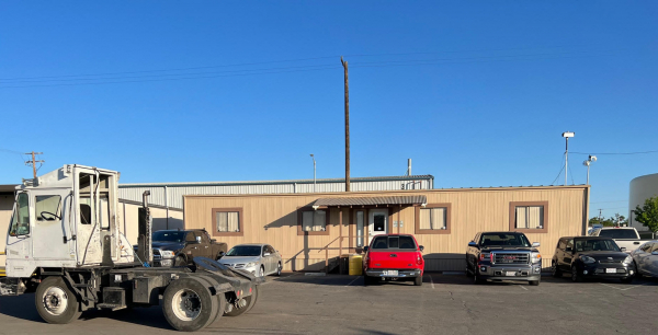 Front of tan building with vehicles parked in front